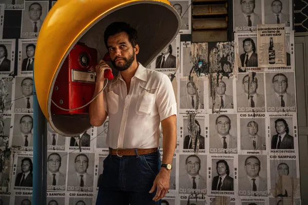 Wagner Moura as a man in a telephone booth in The Secret Agent