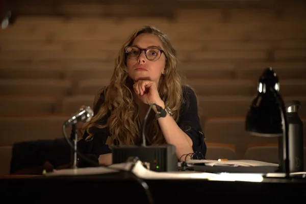 A still from the film Seven Veils. A blond white woman sits behind a desk.