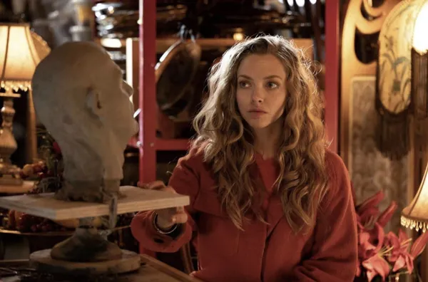 A still from the film Seven Veils. A blond white woman looks at a clay sculpture of a head.