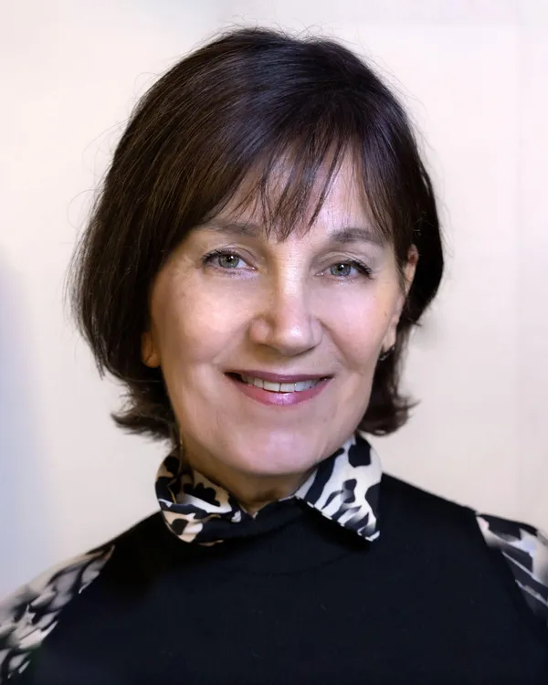 A middle aged white woman with a bob of dark hair.