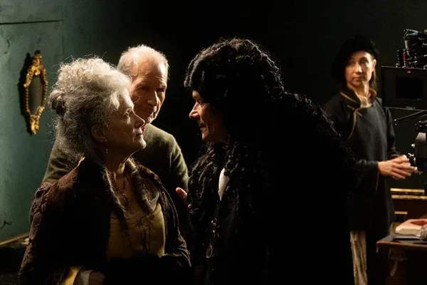 A still from the film Leibnitz. An older woman dressed in 18th Century clothing confronts a man in a large black wig.
