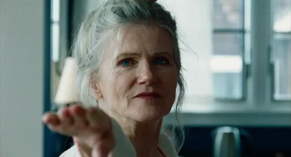 A still from the film We're Not Done Yet. The face of a white woman who is practising yoga.