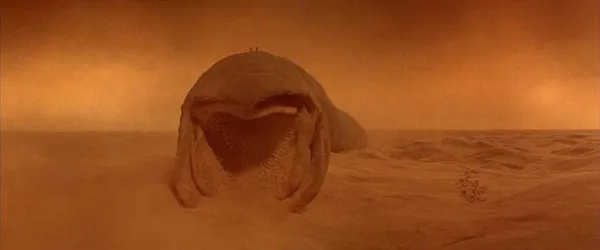 A sandworm in the deserts of Arrakis, surrounded by a cloud of orange spice.