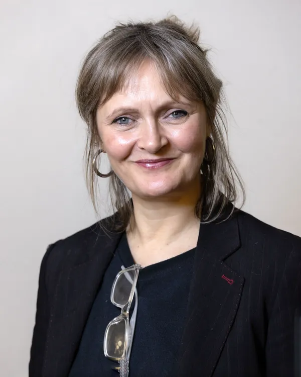 A middle-aged white woman with shoulder-length grey hair.