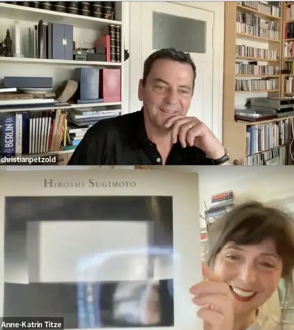 Christian Petzold with Anne-Katrin Titze holding up a Hiroshi Sugimoto photography book