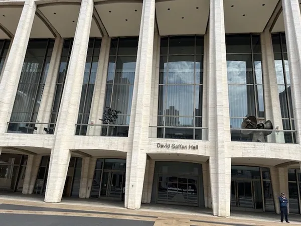 A public building with pale cladding, very tall windows, and the legend 'David Geffen Hall' over its entrance.