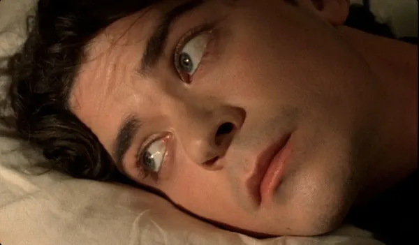 A still from the film Weightless. A close-up of the face of a young white man with Mediterranean features.