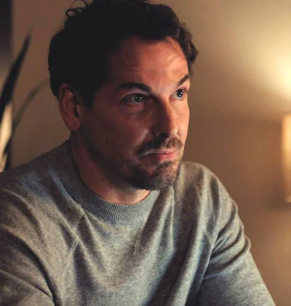 A still from the film What Marielle Knows. A dark-haired white man wearing a grey jumper.