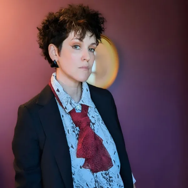 The filmmaker Brooke H Cellars. A slender white woman with short dark hair, wearing a suit and tie.