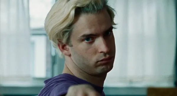 A still from the film We're Not Done Yet. The face of a white man who is practising yoga.