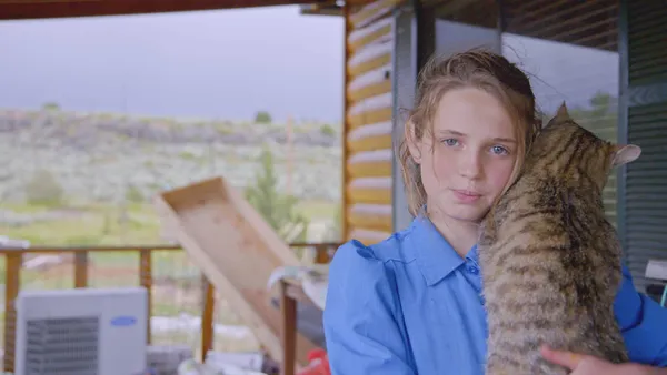 Lori Barlow's daughter holding her cat in Keep Sweet