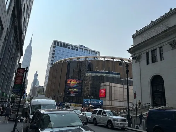 A section of urban street with skyscrapers in the background.