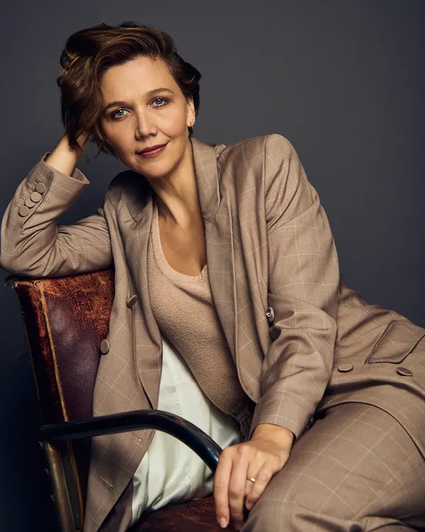 Maggie Gyllenhaal sitting in a chair