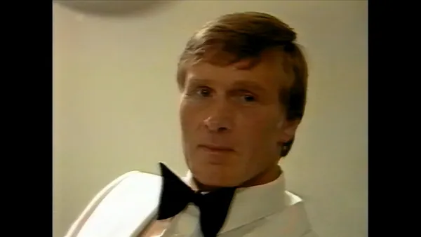The filmmaker Cliff Twemlow. A heavily built, fair-haired white man wearing a white suit with a black bowtie.