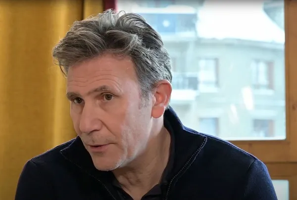 Michel Hazanavicius portrait shot. He is middle-aged with greying short hair