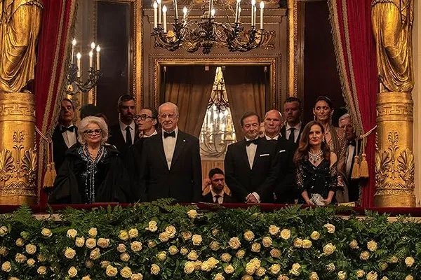 A still from the film La Grazia. A group of conservatively dressed white people fills a gaudily accoutred opera box.