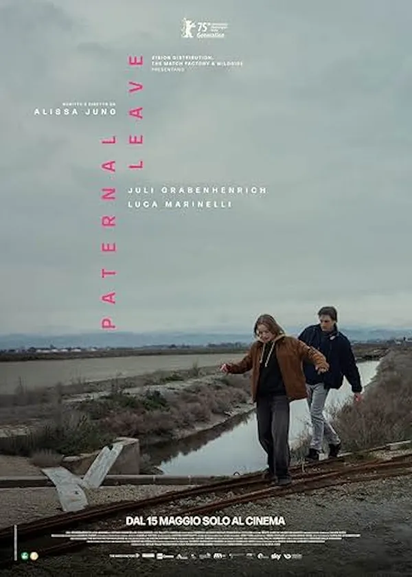 A poster for the film Paternal Leave. Under a large grey sky, a white girl and man walk playfully and precariously along narrow iron tracks at the side of a narrow canal.