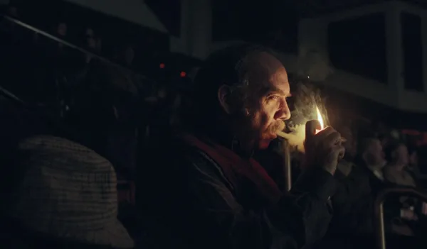 Paul Giamatti lighting his pipe in The Holdovers