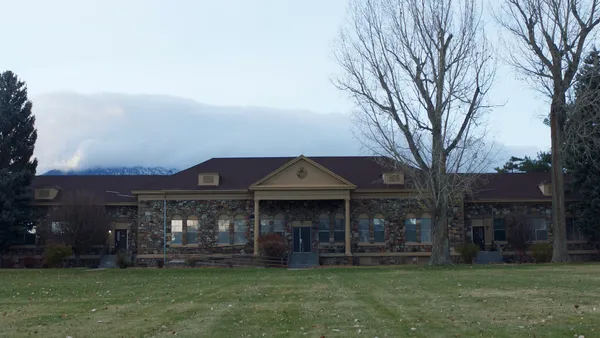 Stewart Residential School. A long, low stone building with a large, flat green lawn.