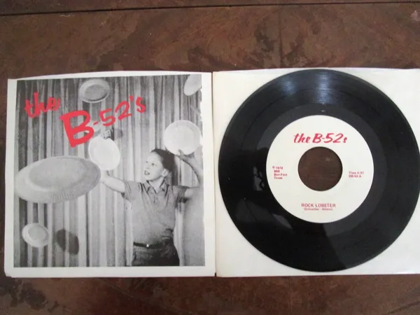 A vinyl record sits beside its sleeve, which bears the words 'The B-52s'