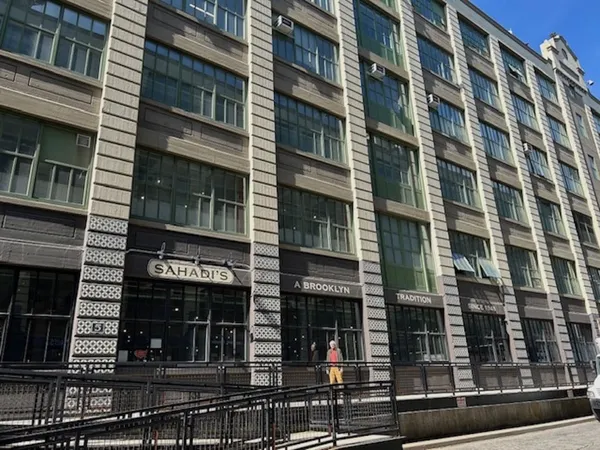 A tall concrete building. A sign over one of the doors says 'Sahadi's'.