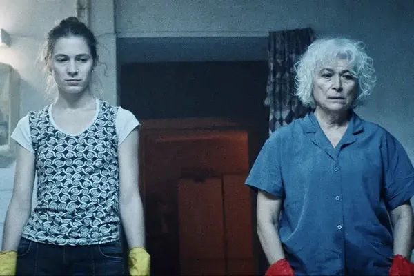 Two women stand in marigolds looking serious