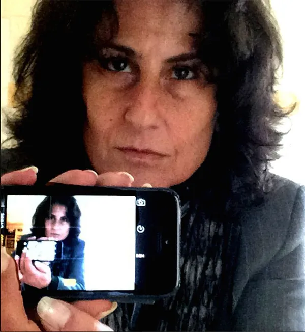 Portrait of Vivianne Perelmuter, you can see her holding a camera with the image of herself on it