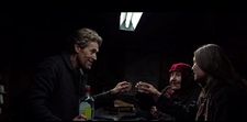 Clint (Willem Dafoe) toasts his Russian travellers (Valentina Rozumenko, Cristina Chiriac)