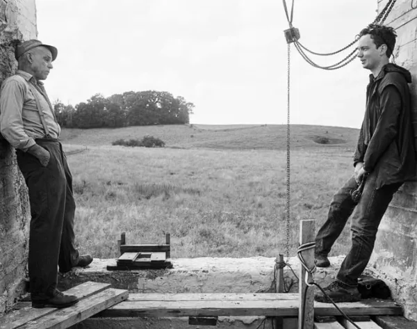 Denis Lavant and John Skoog at either side of part of the set of Redoubt