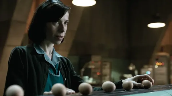 A still from the film The Shape Of Water. A white woman presents a row of hen's eggs.