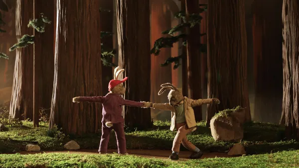 A still from the animated film Tennis, Oranges. An elderly female and male rabbit dance together in the woods.